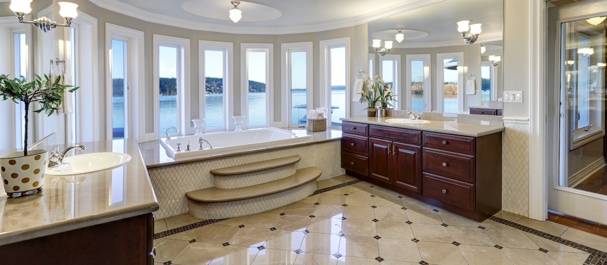 Remodeled bathroom showing tub, flooring, and two vanities